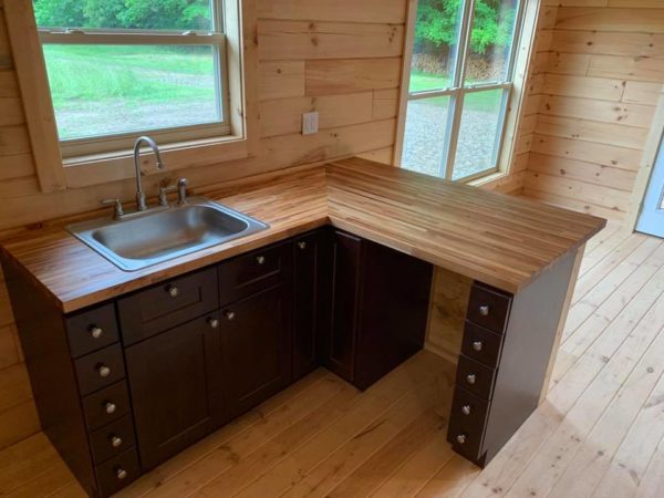 Wooden kitchen with dark cabinets and sink.