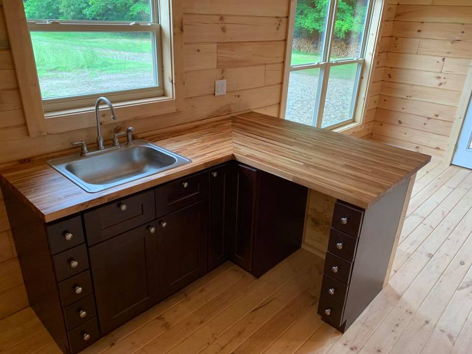 Wooden kitchen with dark cabinets and sink.
