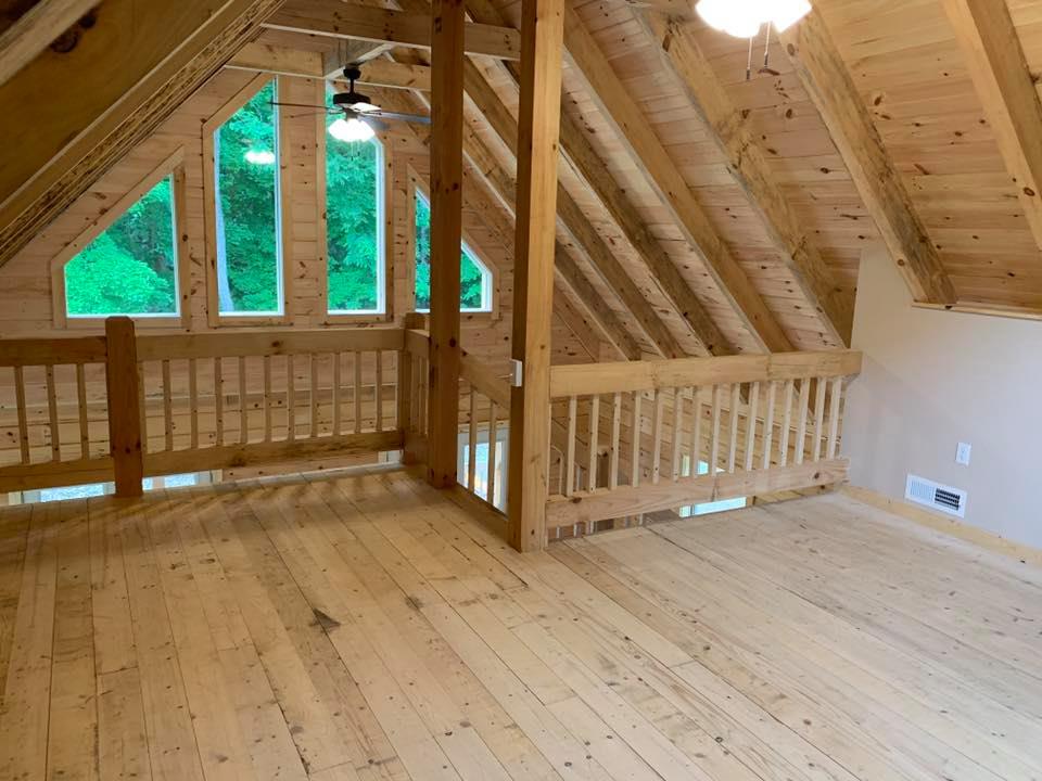 Wooden attic interior with large windows.