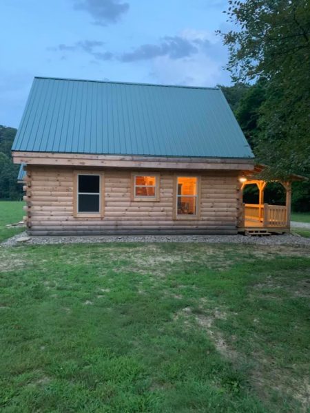 Cozy log cabin with glowing windows at dusk.