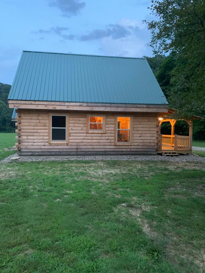 Cozy log cabin with glowing windows at dusk.