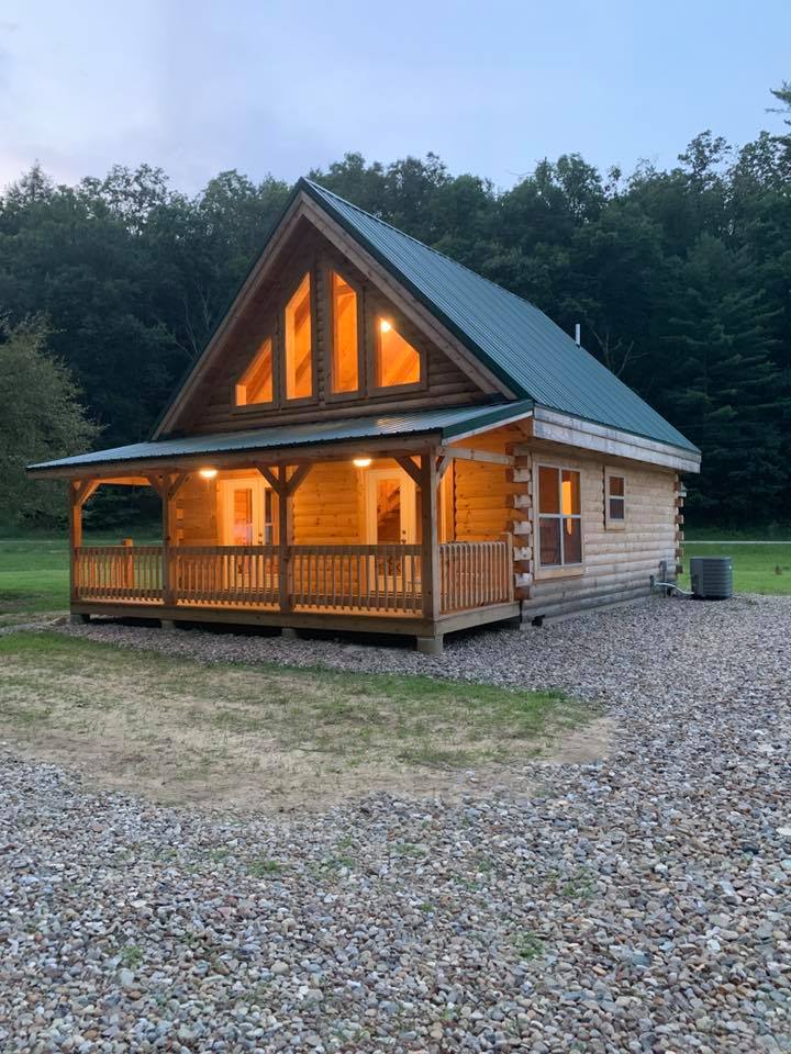 Cozy log cabin with illuminated windows.