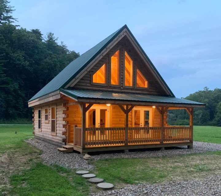 Cozy wooden cabin with porch at dusk.