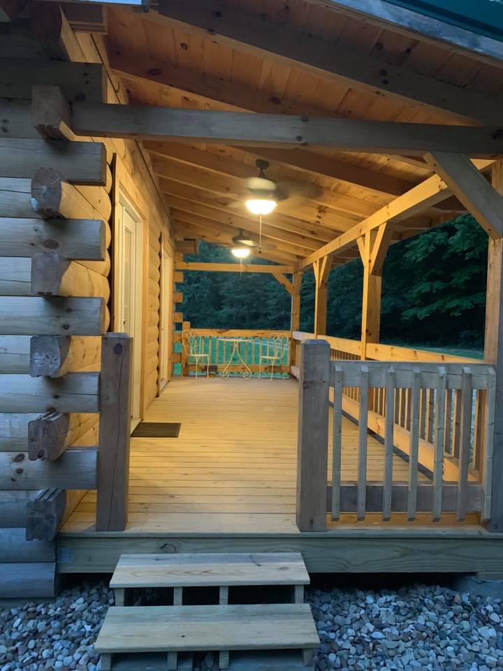 Wooden cabin porch with ceiling fan lights.