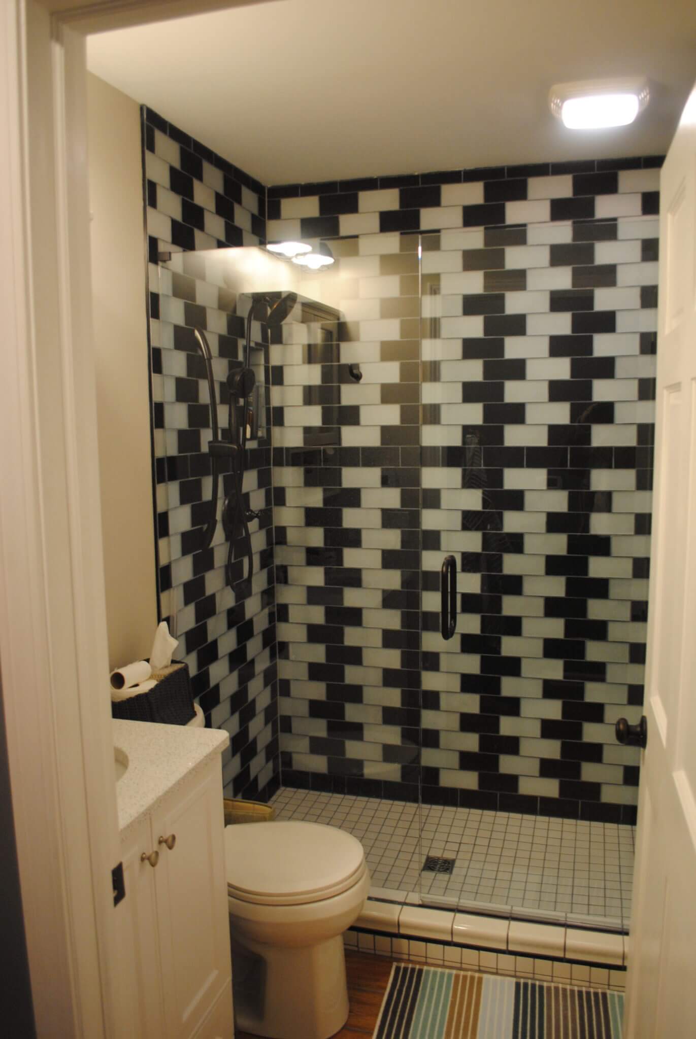 Modern bathroom with black and white tiles.
