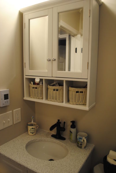 Bathroom vanity with mirror and storage baskets.