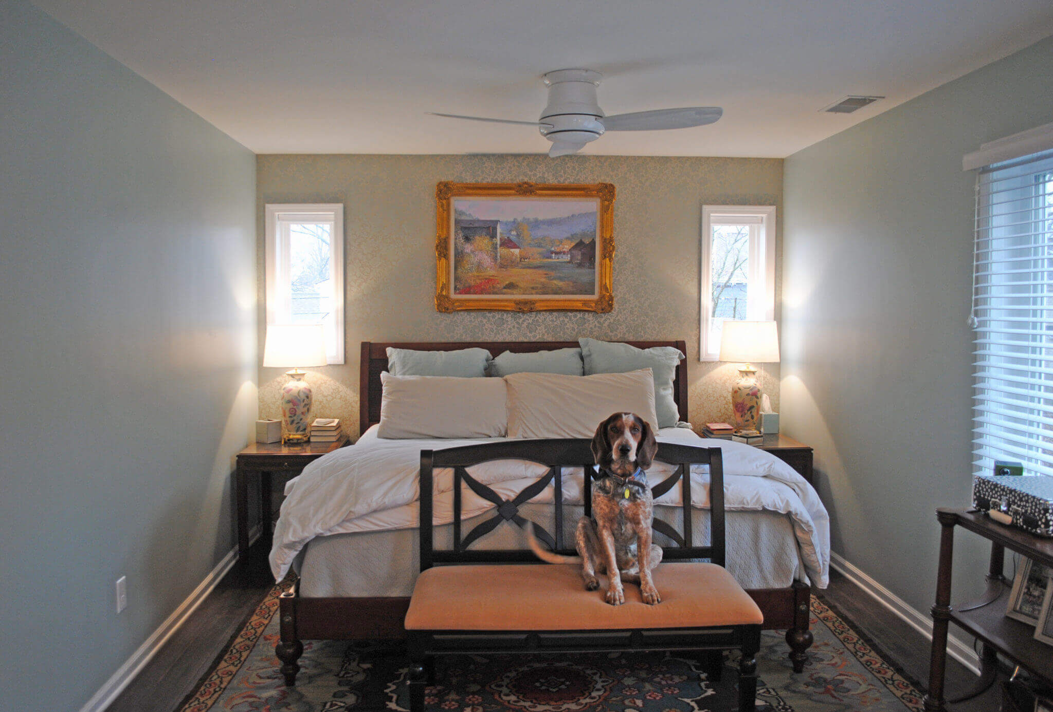 Dog sitting in cozy bedroom.