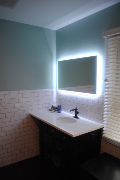 Bathroom sink with illuminated mirror.