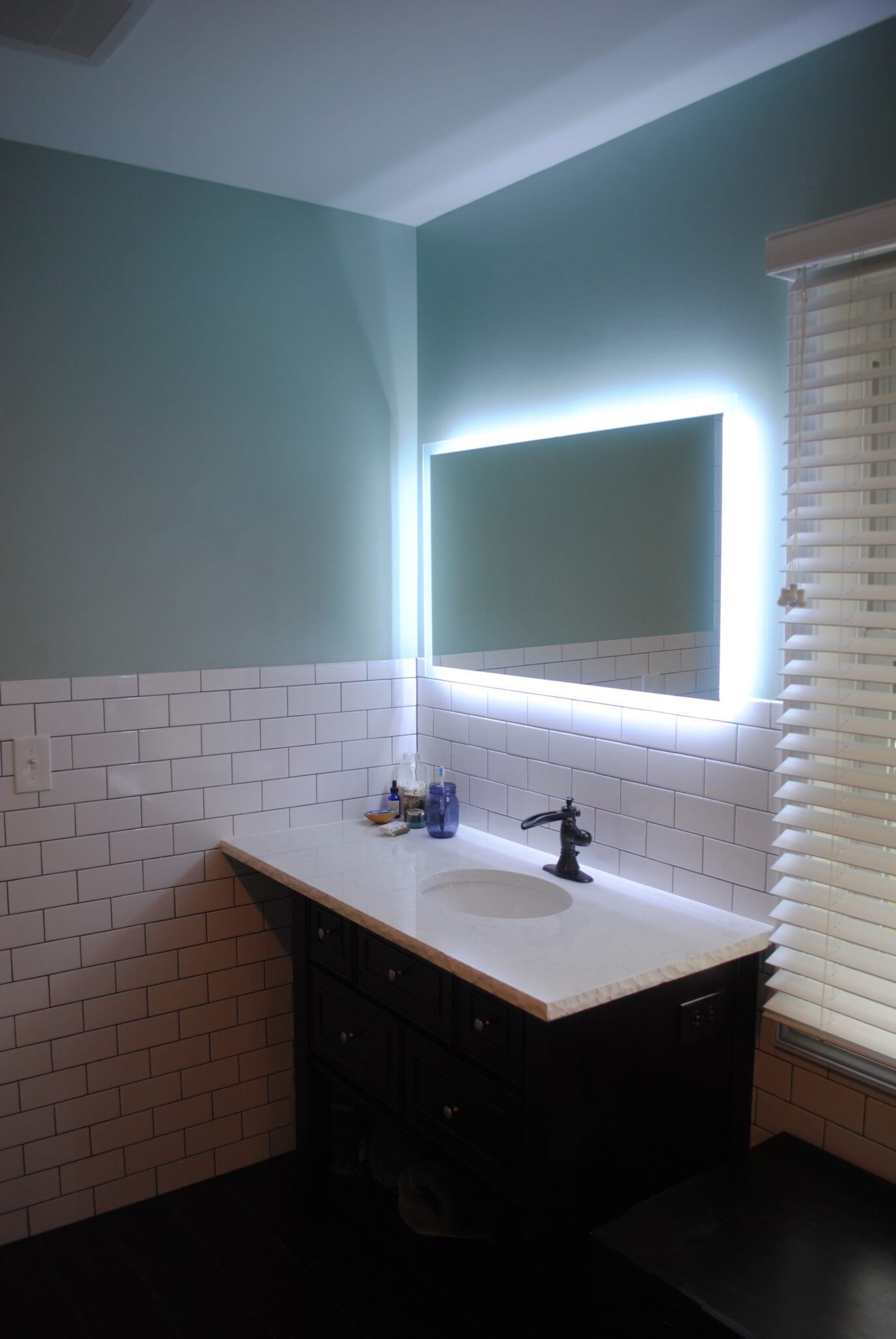 Bathroom sink with illuminated mirror.
