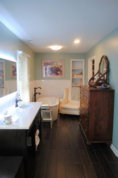 Elegant bathroom with tub and wooden dresser.