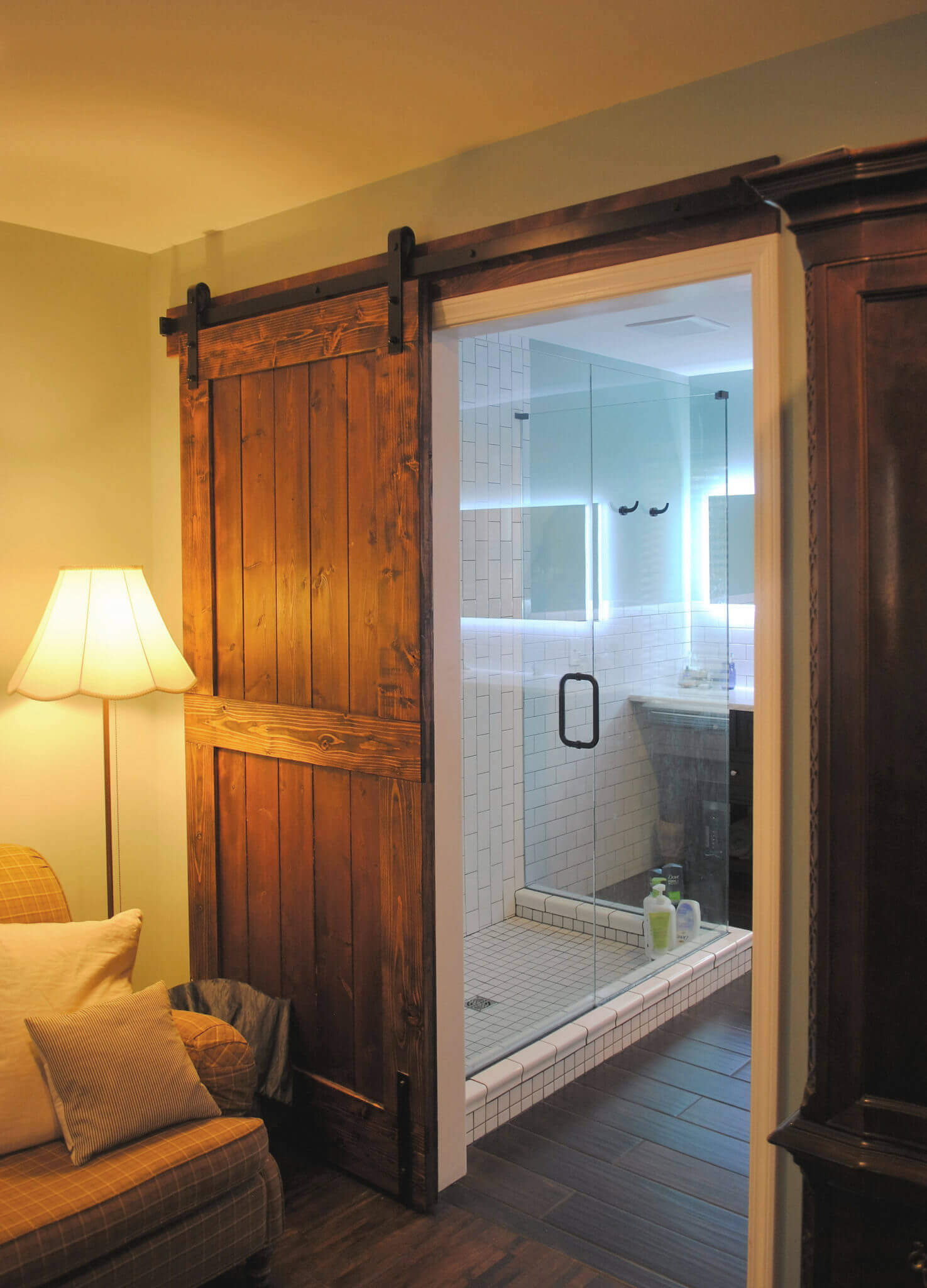 Sliding barn door leading to modern bathroom.