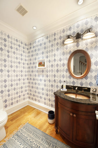 Elegant bathroom with patterned wallpaper and vanity.