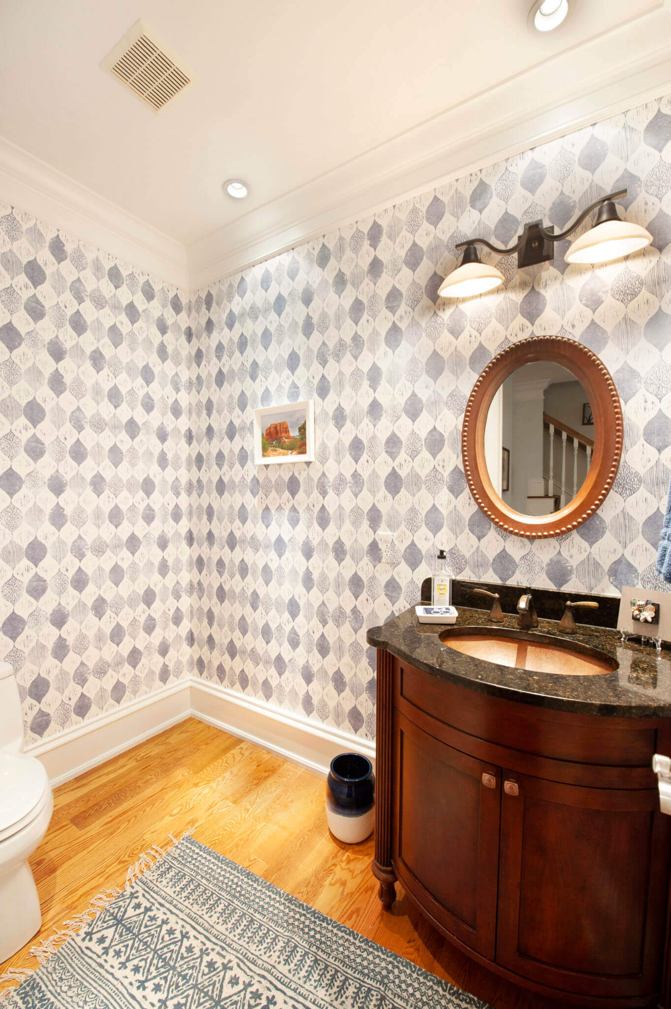 Elegant bathroom with patterned wallpaper and vanity.
