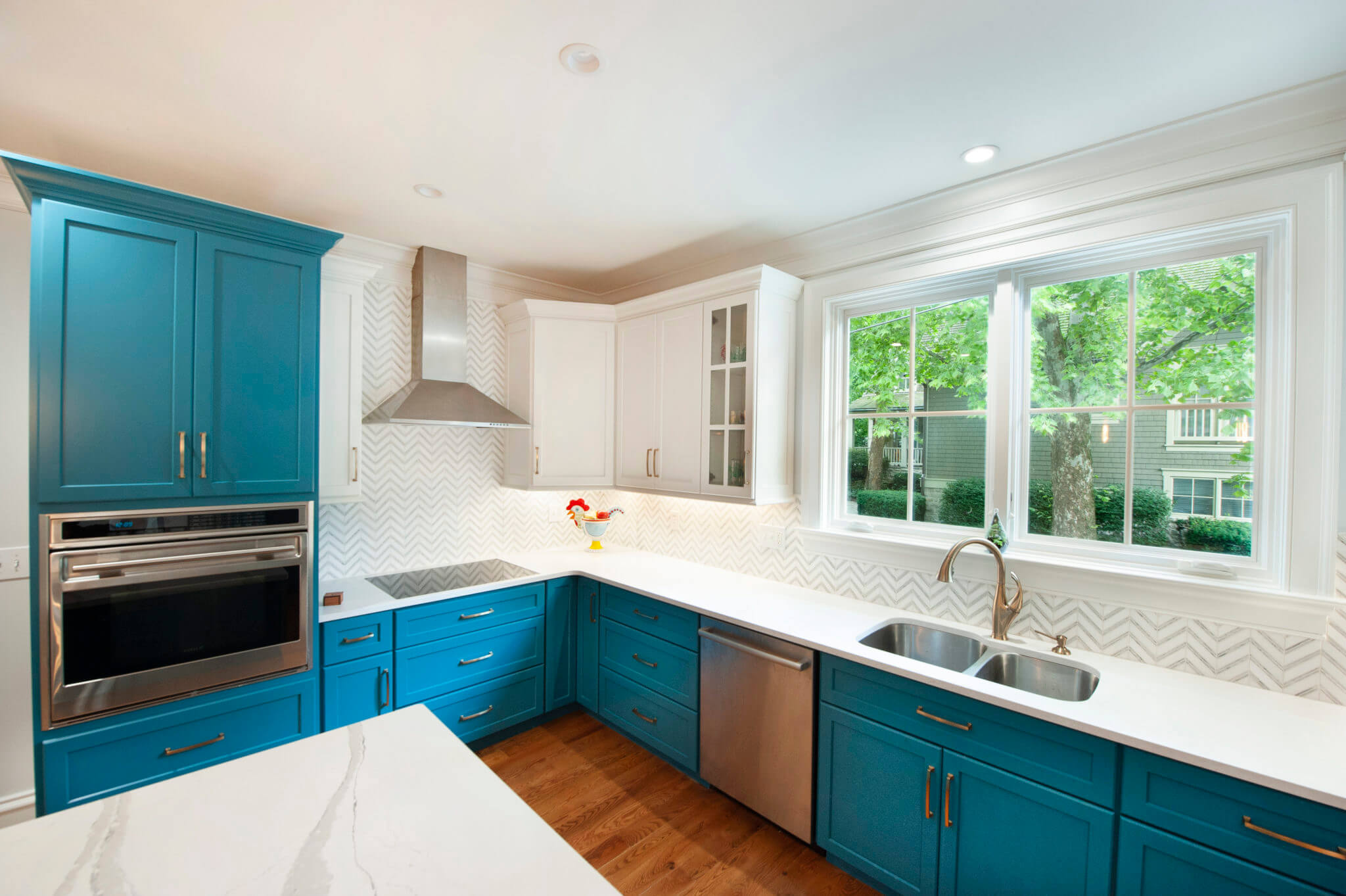 Modern kitchen with blue cabinets and windows.