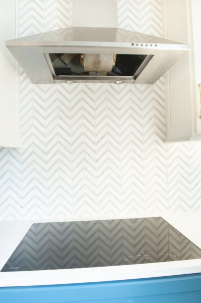 Modern kitchen with stove and range hood.