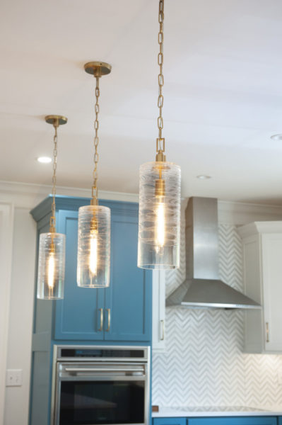 Modern kitchen with pendant lights and cabinetry.