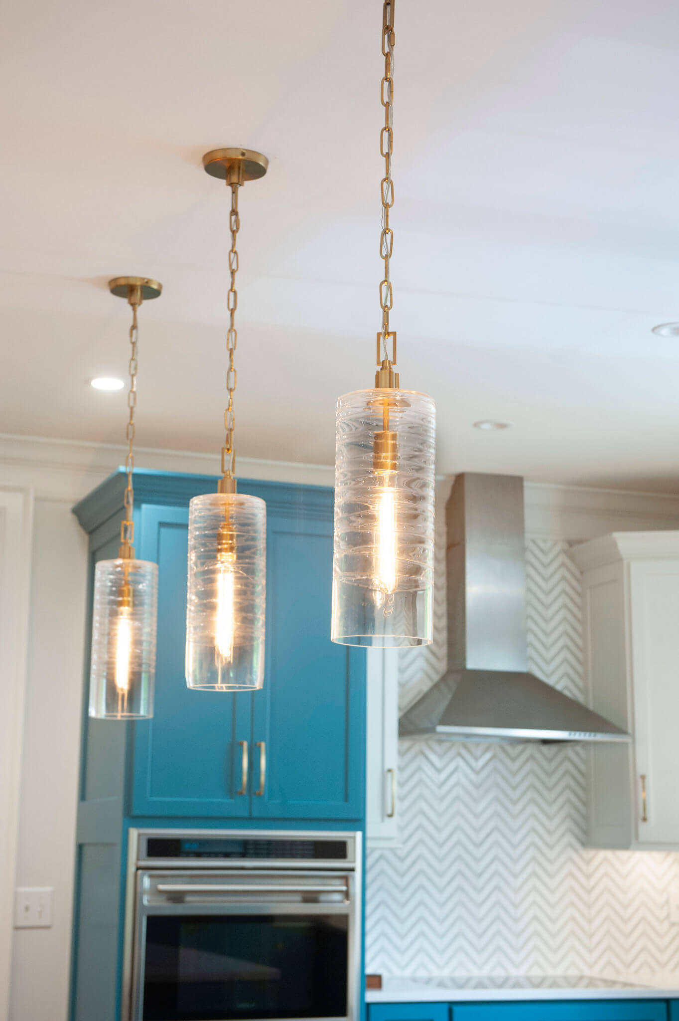 Modern kitchen with pendant lights and cabinetry.