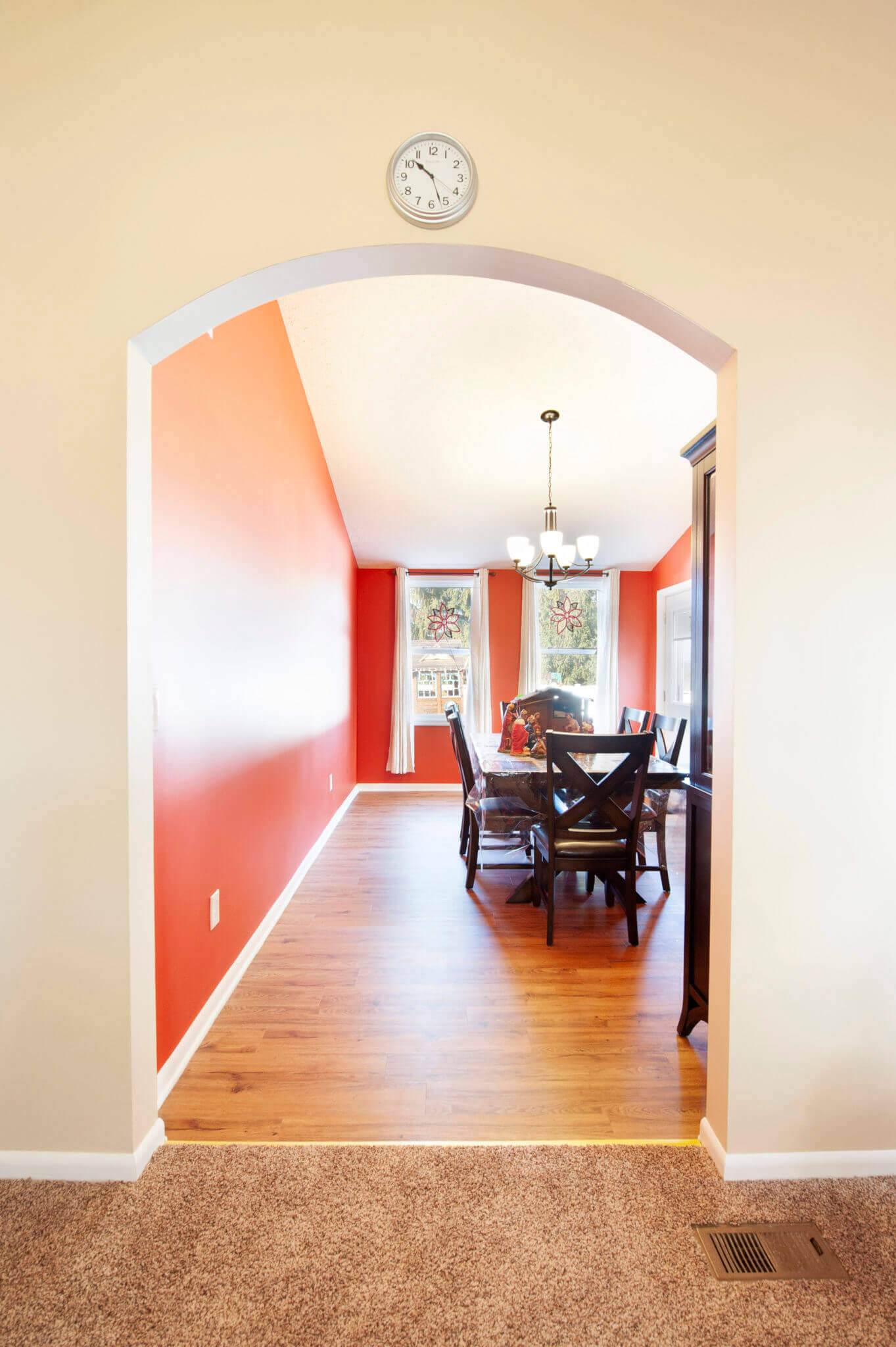 Dining room with wooden floor and archway.