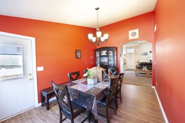 Dining room with red walls and chandelier.
