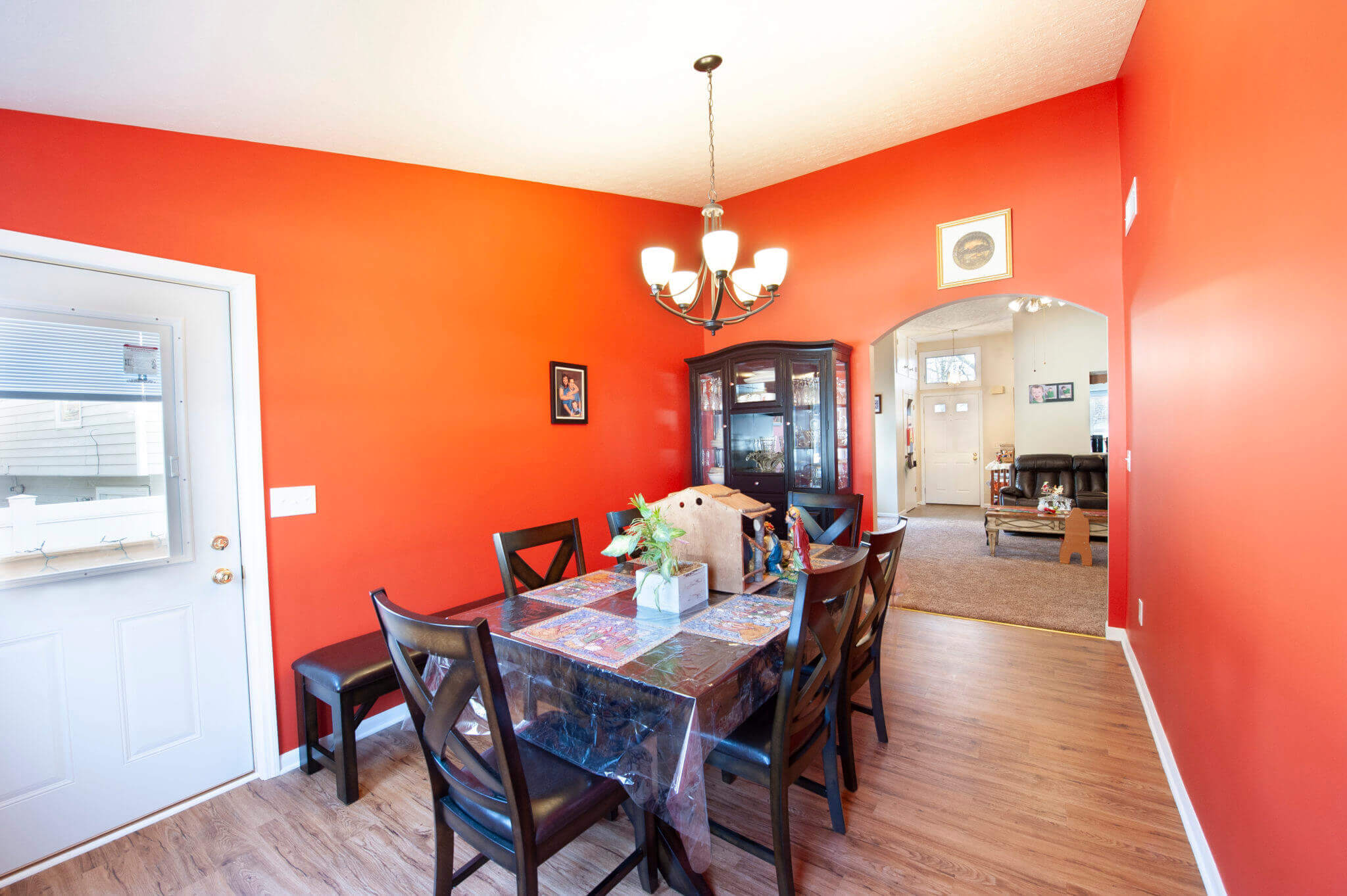 Dining room with red walls and chandelier.