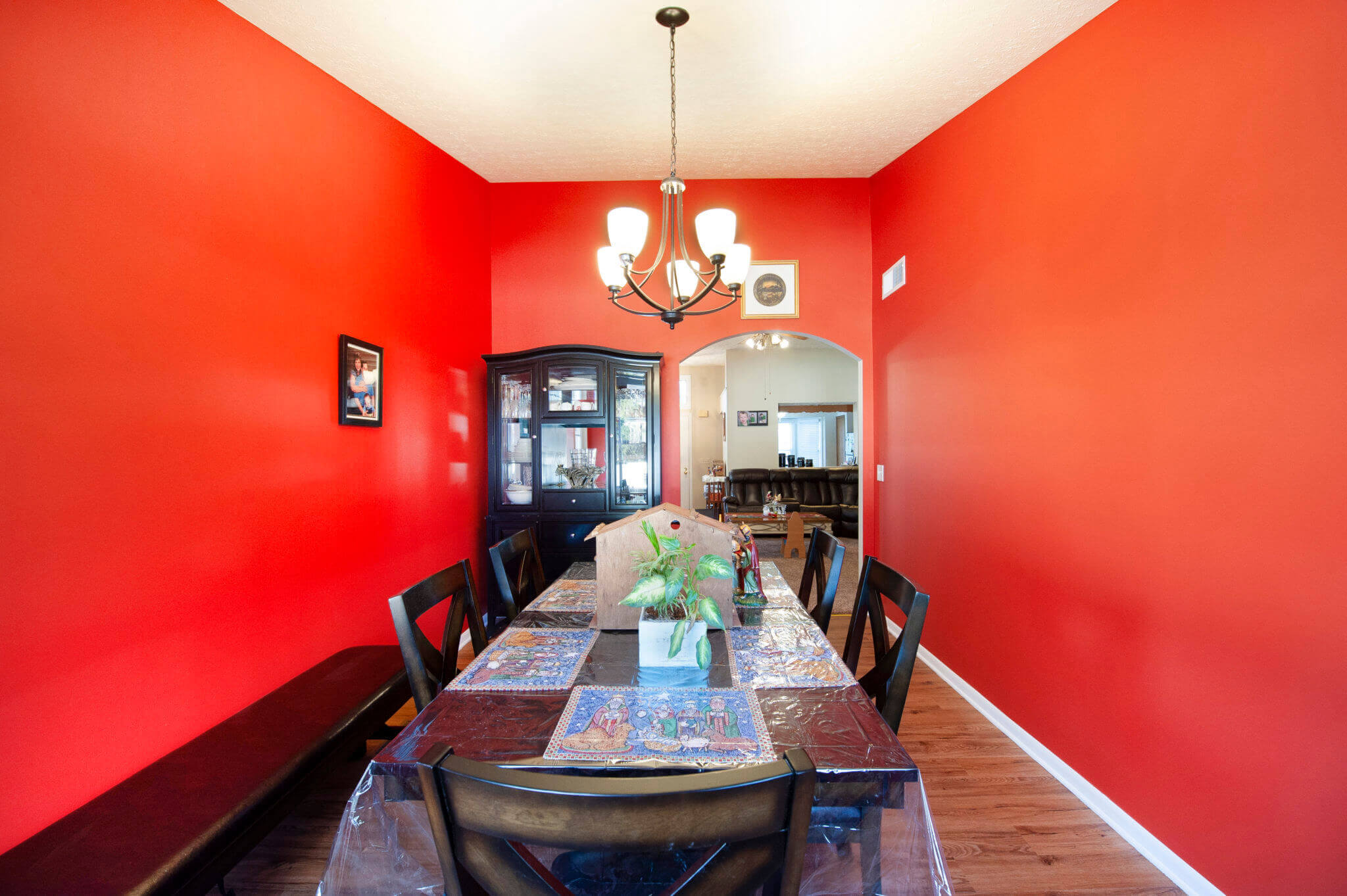 Red dining room with table and chandelier.