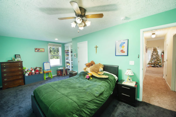 Child's bedroom with toys and Christmas tree.
