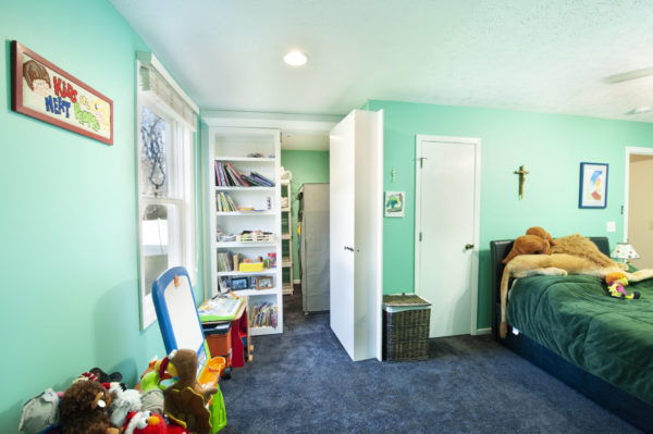 Child's bedroom with toys and turquoise walls.