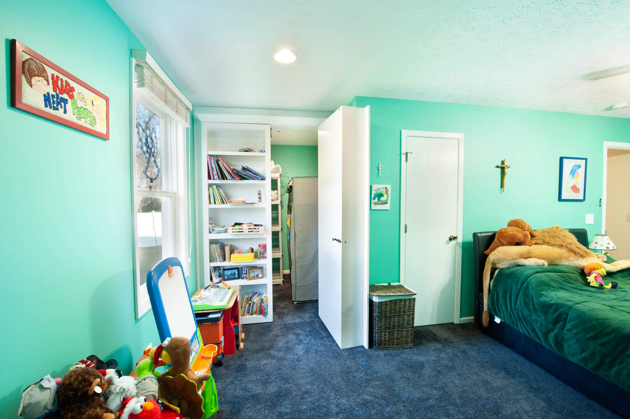 Child's bedroom with toys and turquoise walls.