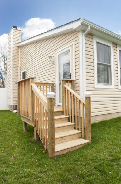 Small porch with wooden steps and railing.