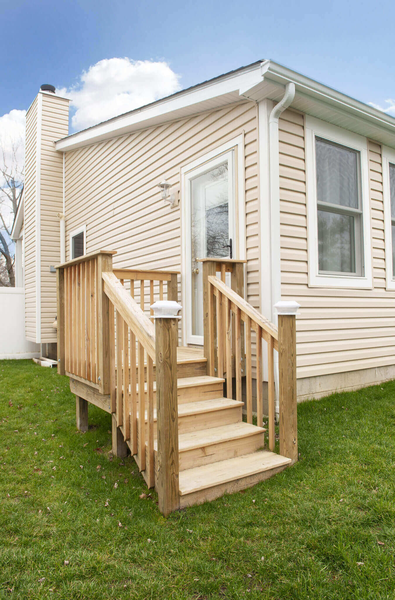 Small porch with wooden steps and railing.