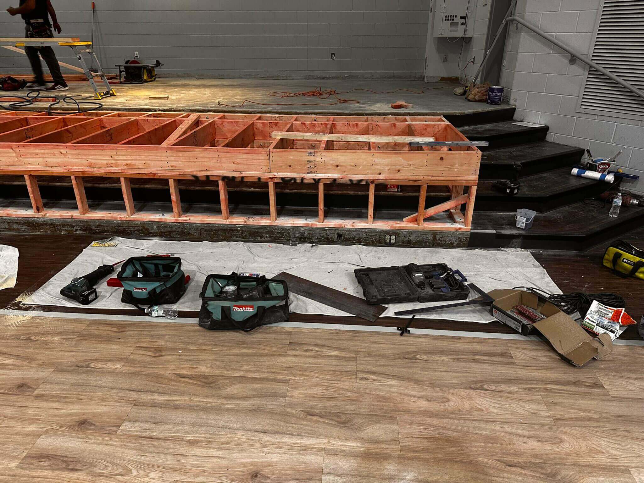 Construction tools and materials on wooden floor.