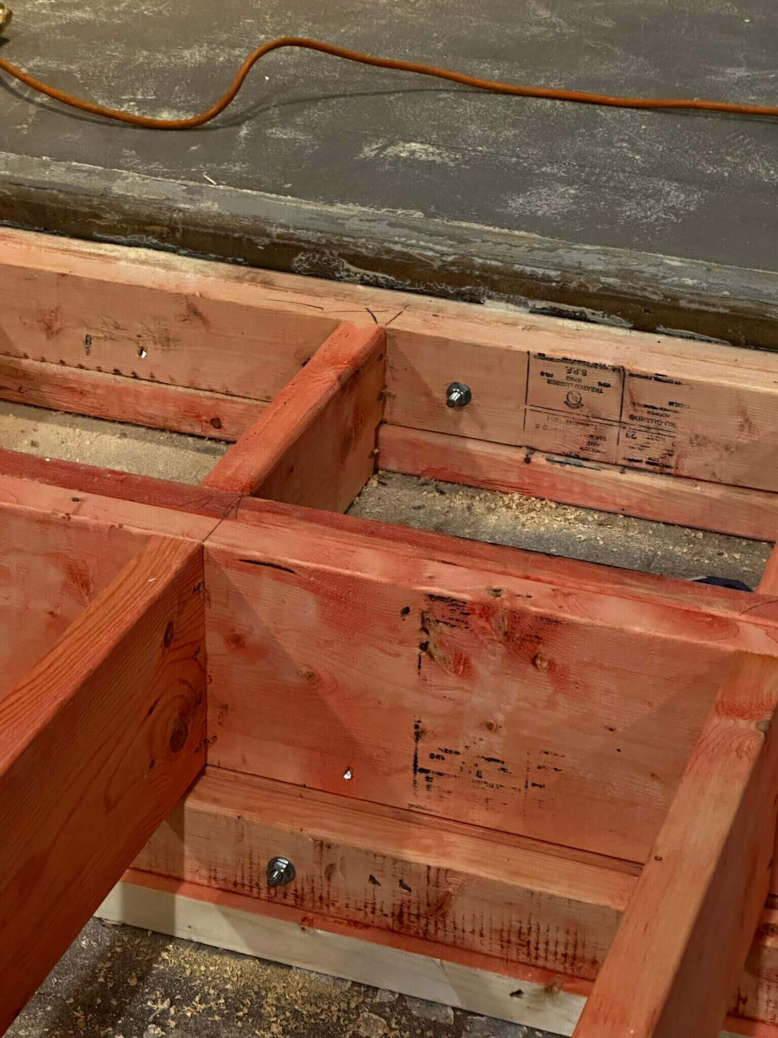 Wooden beams construction with visible bolts.